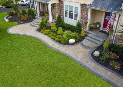 Aerial view of a house in Aberdeen with a stone walkway, manicured lawn, and landscaped garden beds by Solid Brick Contracting.