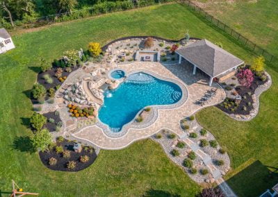 Aerial view of an Aberdeen backyard featuring a pool, hot tub, patio, pavilion, and beautifully landscaped garden areas with elegant hardscaping.