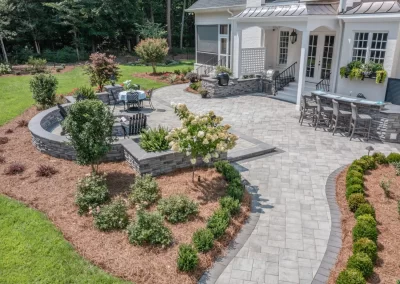 Spacious backyard patio with stone pavers, outdoor seating, bar area, and landscaped garden beds—expertly crafted by Solid Brick Contracting and perfect for stylish outdoor living in Aberdeen.